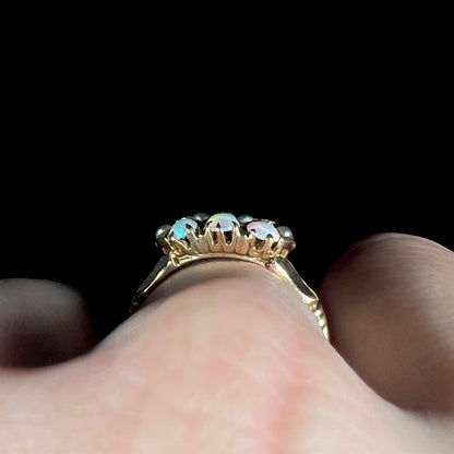 Victorian prong-set opal ring worn on hand and viewed from side gallery profile view; one pearl accent appears to be lifting from the setting