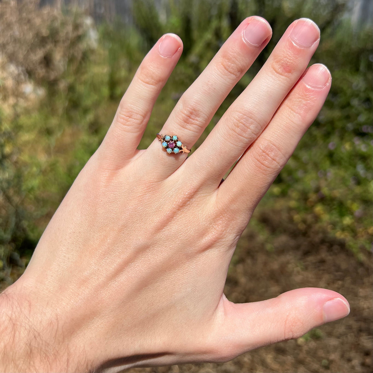1880s era Victorian women's opal and pink tourmaline cluster ring in 9k gold, worn on hand under natural light
