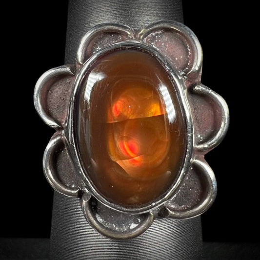 Vintage handmade fire agate ring with red-orange iridescence on ring display.