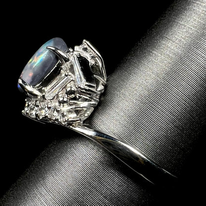 Side view of a vintage Japanese platinum ring set with dark Australian opal and diamond accents.  The ring's polished shank is in view.