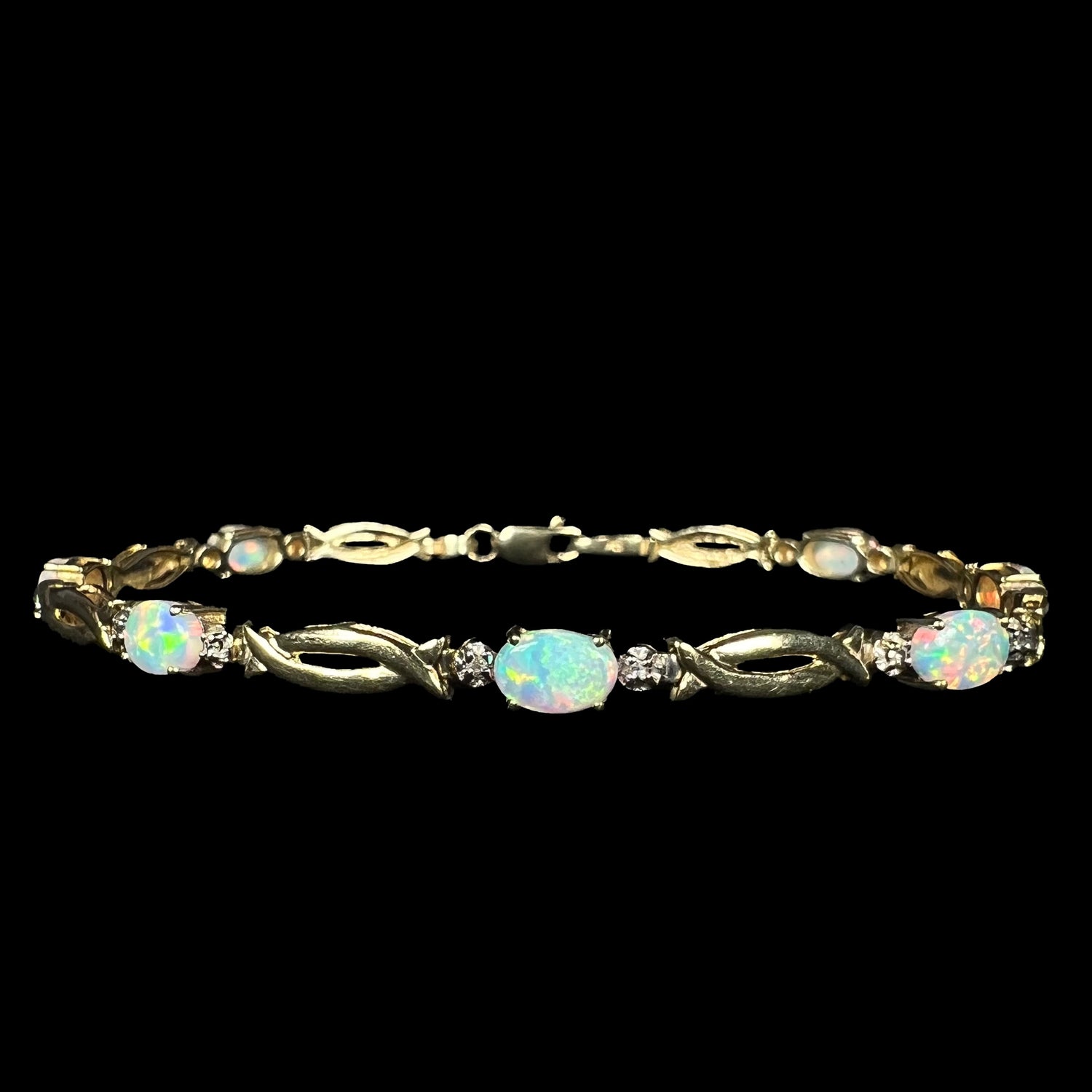 Front view of a vintage 1990s lab-created opal and diamond tennis bracelet in 10k yellow gold with open, modernist style links.