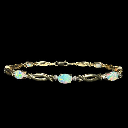 Front view of a vintage 1990s lab-created opal and diamond tennis bracelet in 10k yellow gold with open, modernist style links.