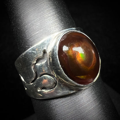 A vintage Mexican fire agate ring in sterling silver, shown from an angle against a dark backdrop.