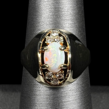 Close-up of vintage c.1960s Mid-Century Modern domed 14k gold Australian opal and diamond ring shown on ring display