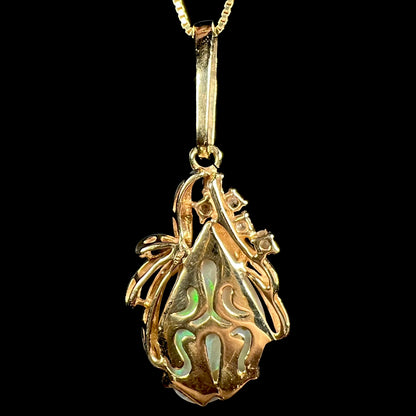 Back side of a vintage, 1980s-era Modernist 14k yellow gold pendant with ornate design, shown on black backdrop.