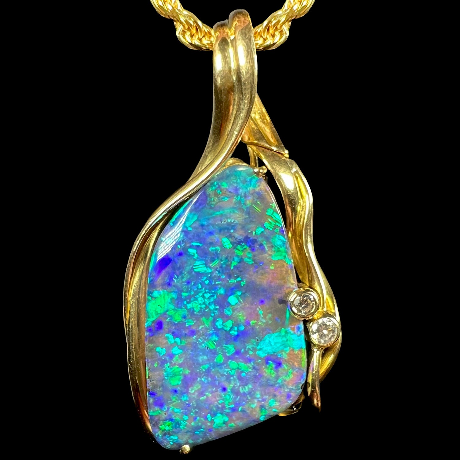 Front macro view of a 1980s 18k gold modernist pendant featuring a B5 blue-green Australian boulder opal and diamond accents.