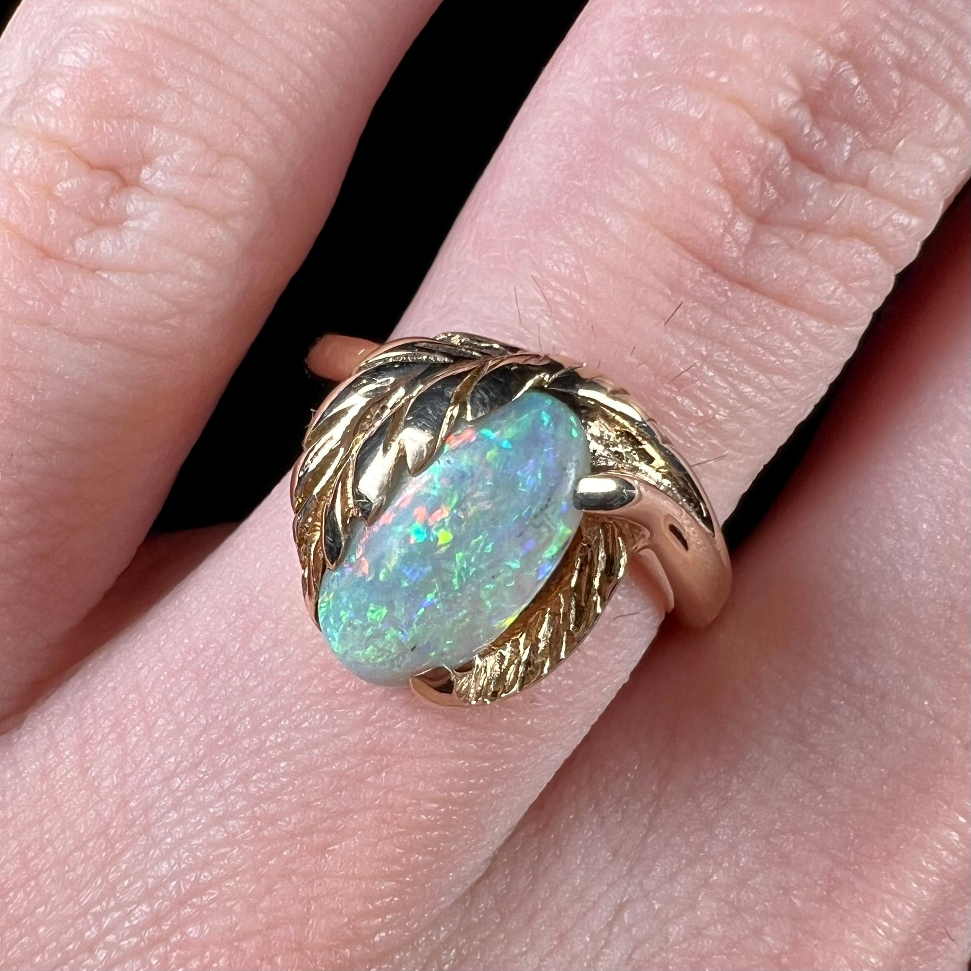 A vintage gold ring with a leaf design set with a natural Coober Pedy  opal.