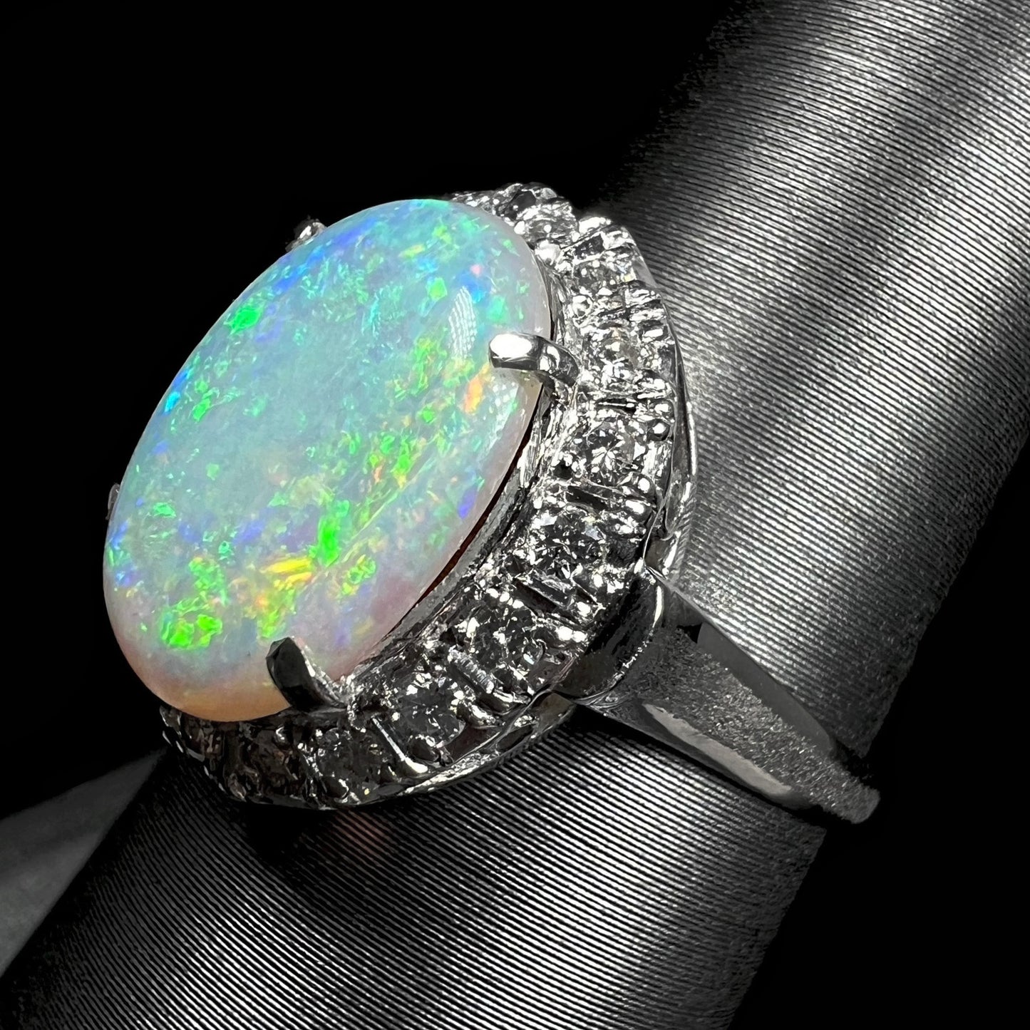 The side angle of a vintage opal and diamond halo ring.  The platinum on the sides of the shank is textured.