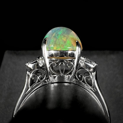 Undercarriage view of a vintage platinum fire opal ring, showcasing intricate filigree details and a 2.28ct Mexican fire opal center stone.