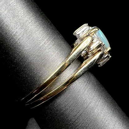 Vintage reversible gold opal and diamond flip ring shown from side view on ring display, the ring's shanks in focus