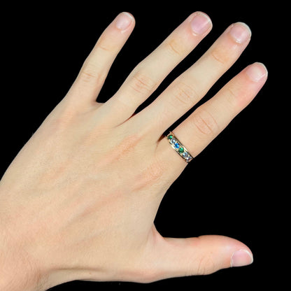 A ladies' yellow gold band set with green, dark blue, light blue, and light purple stones.