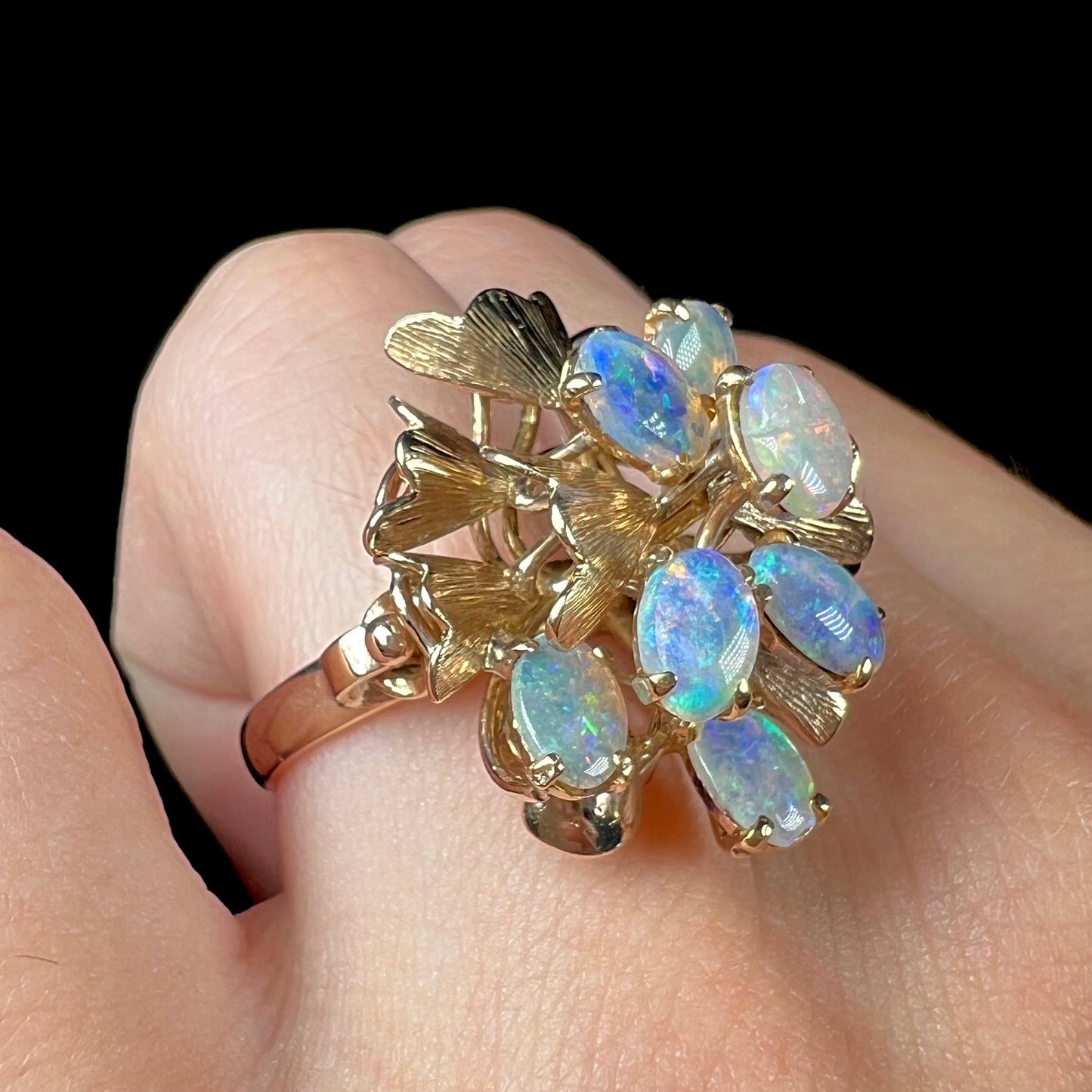 A ladies' vintage, modernist style opal cluster ring in yellow gold.  The ring is tall with a high profile.