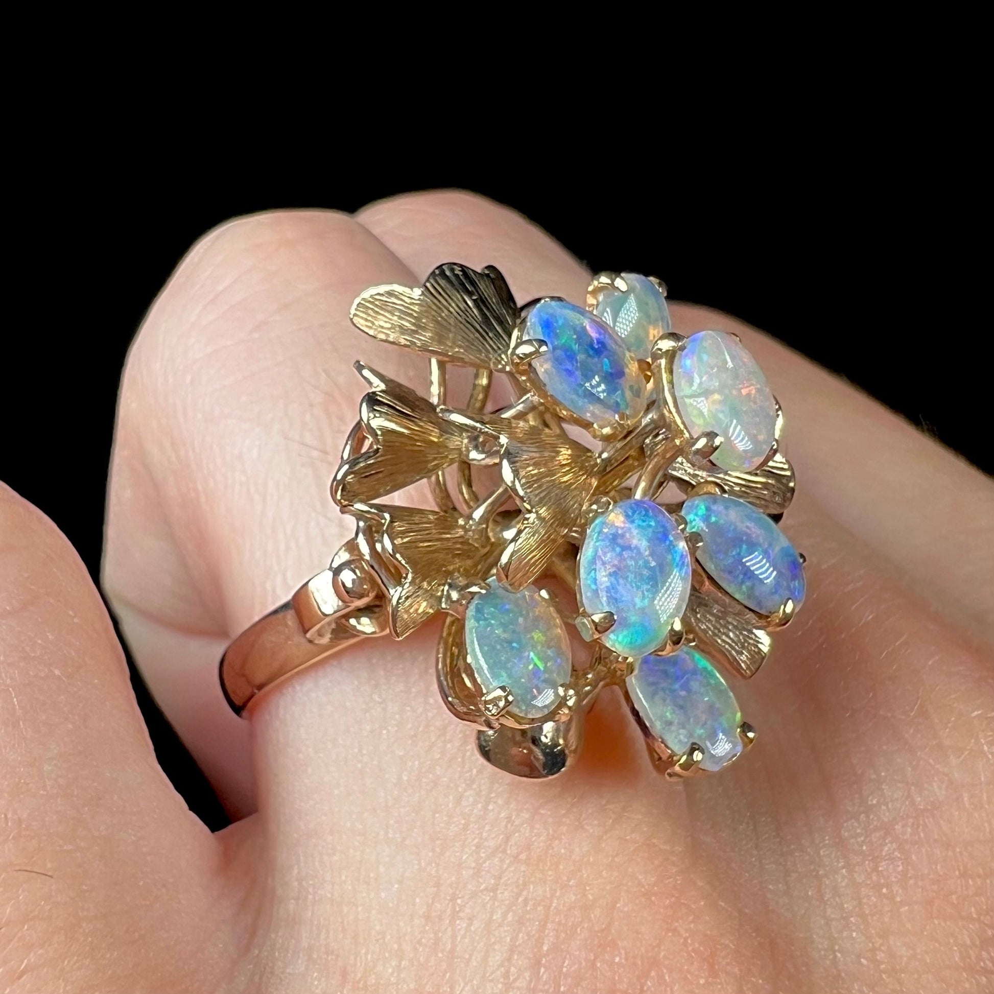 A ladies' vintage, modernist style opal cluster ring in yellow gold.  The ring is tall with a high profile.
