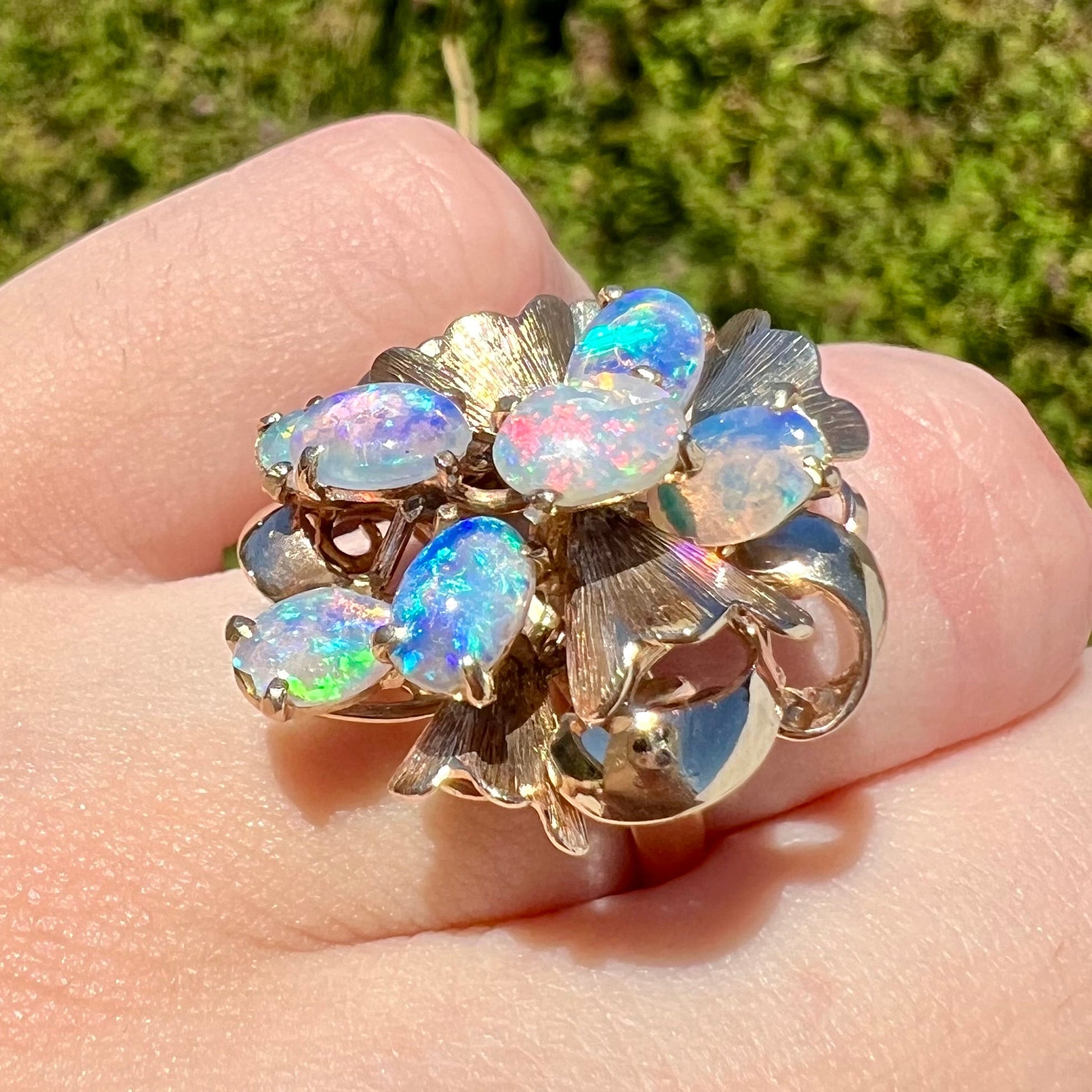 A ladies' vintage, modernist style opal cluster ring in yellow gold.  The ring is tall with a high profile.