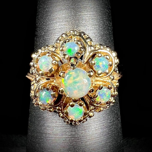 A vintage, mid-century style round opal cluster ring in yellow gold.