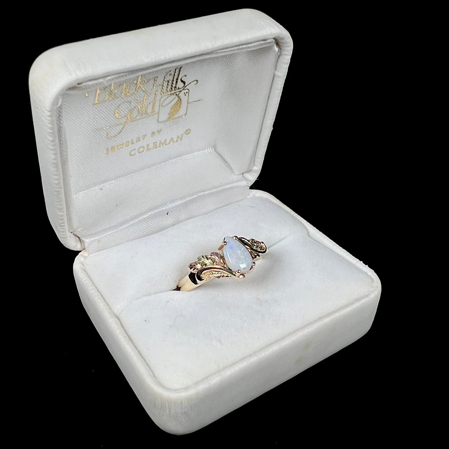A ladies' two-tone yellow and rose Black Hills gold opal and diamond ring.  The opal is a pear shaped cabochon.