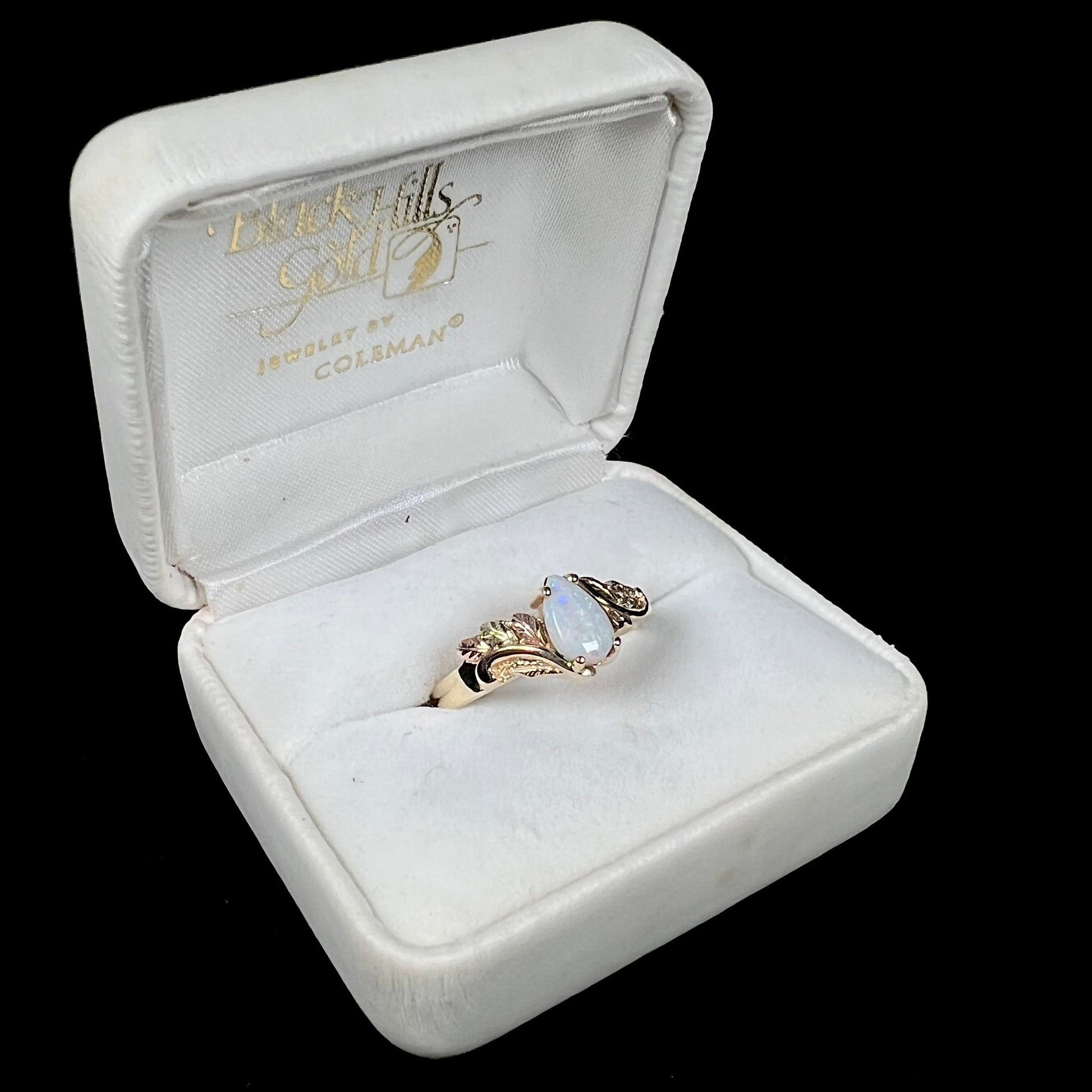 A ladies' two-tone yellow and rose Black Hills gold opal and diamond ring.  The opal is a pear shaped cabochon.