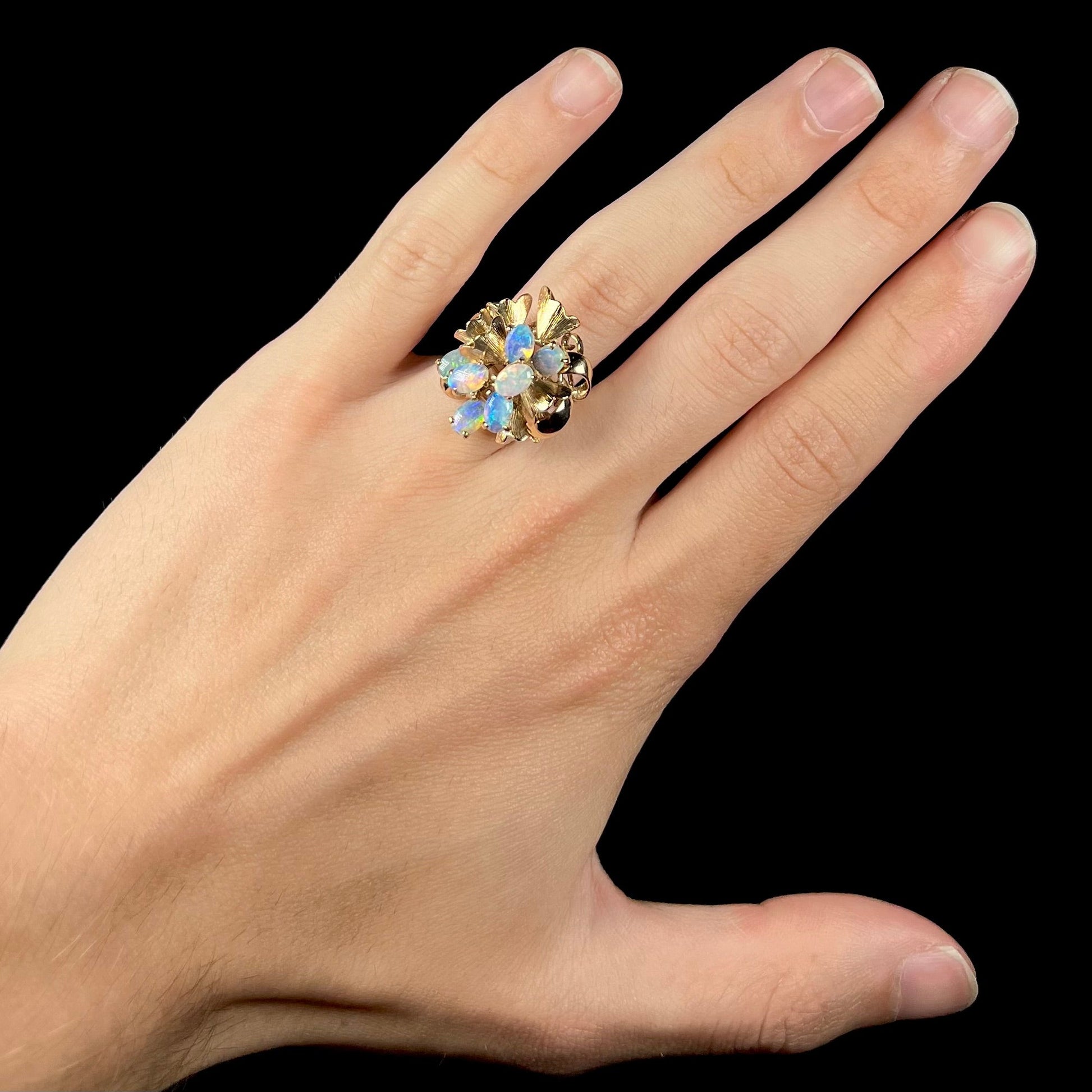 A ladies' vintage, modernist style opal cluster ring in yellow gold.  The ring is tall with a high profile.