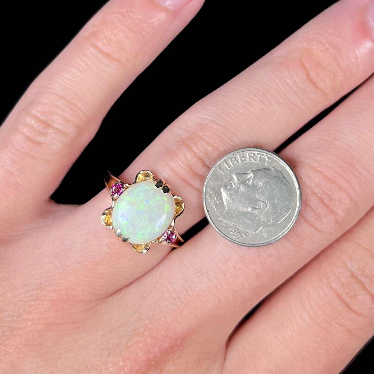 A turn of the century Art Nouveau opal and pink sapphire ring.   The ring is yellow gold and palladium.  The opal is green and purple.