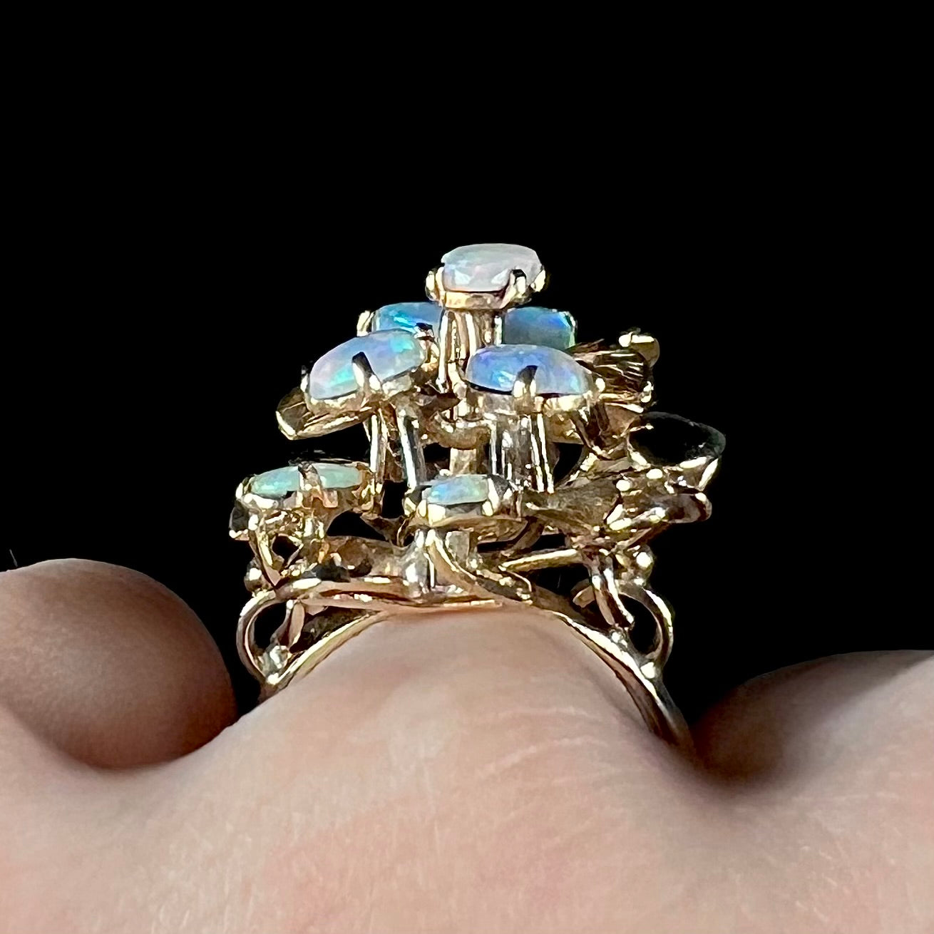 A ladies' vintage, modernist style opal cluster ring in yellow gold.  The ring is tall with a high profile.