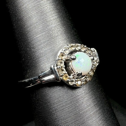 White Australian opal ring with smoky quartz halo in sterling silver, shown close-up from angle
