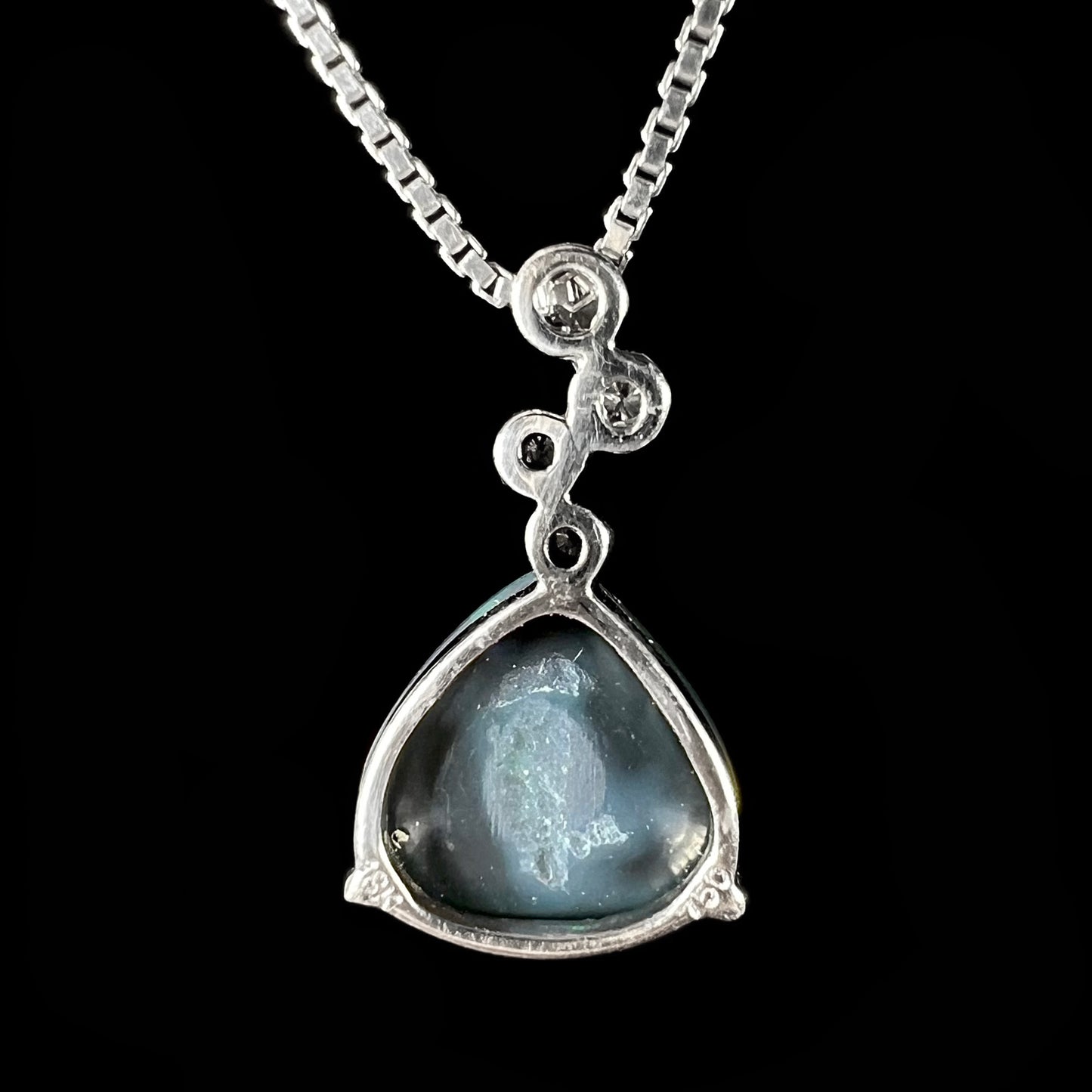 Back view of a white gold opal necklace showing the open basket frame with “18K” and “750” hallmarks.