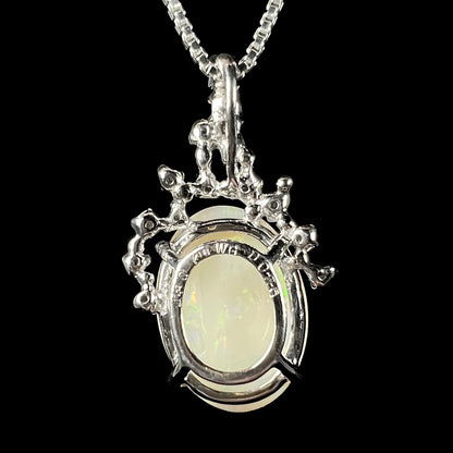 Back view of a white gold opal necklace, showing the openwork basket setting with “K18 WG” and stone weight engraving.