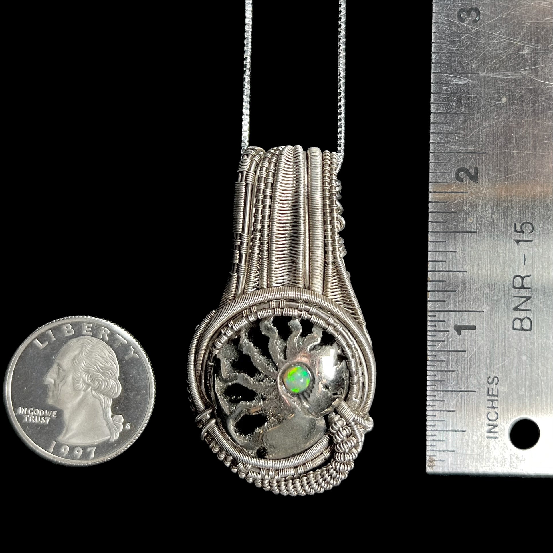 2 inch-long wire wrapped ammonite and Ethiopian opal pendant shown between US quarter coin and ruler for scale.