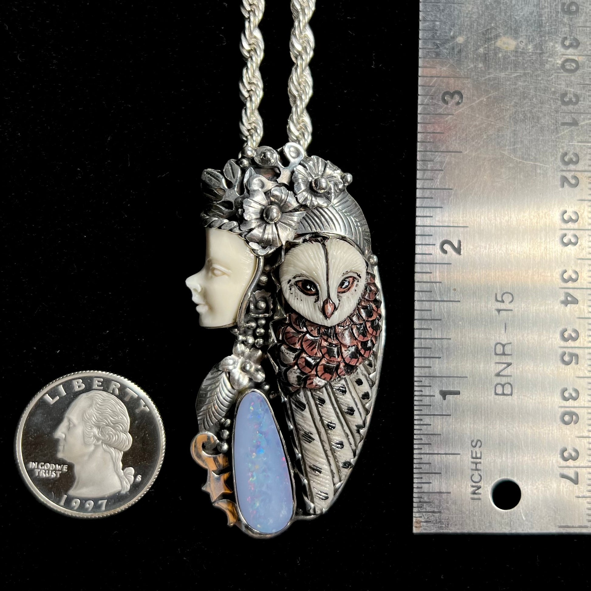 A woman and owl necklace with a nature-inspired motif, made from sterling silver, bone, and an opal doublet.