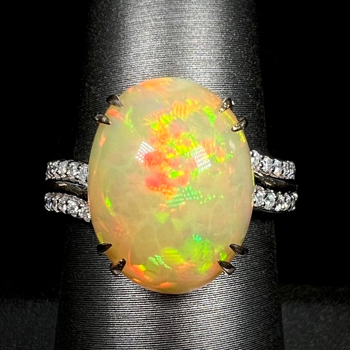 Close-up macro of women's 14k gold Ethiopian opal and diamond cocktail ring with double-prong design on display