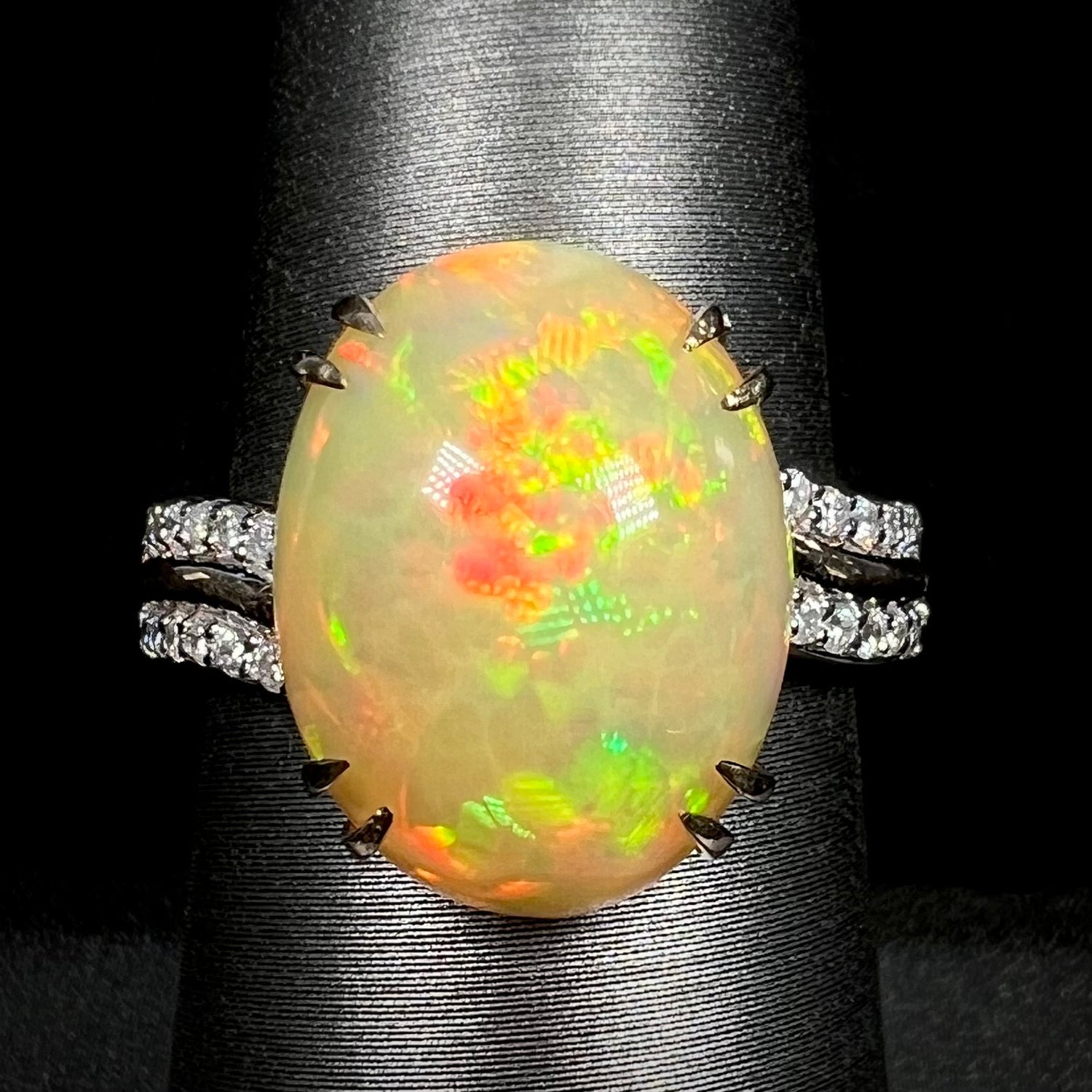 Close-up macro of women's 14k gold Ethiopian opal and diamond cocktail ring with double-prong design on display