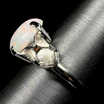 Side view of an Australian opal women's ring in 14k white gold, shown on ring display; the ring's shank and textured shoulders are in focus