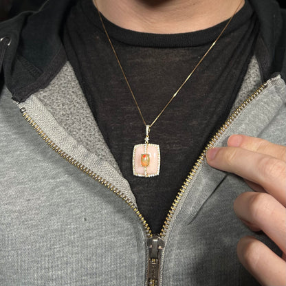 A women's dainty cushion cut pink Peruvian opal, Ethiopian opal, and diamond necklace in 14k gold worn around a person's neck against dark shirt.