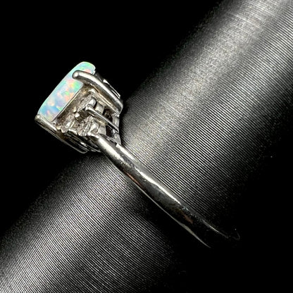 Side shank view of women's estate sterling silver opal ring, shown on ring display.  The shank has light wear.