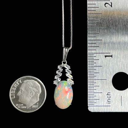 1.2 inch-long women's Ethiopian opal and CZ pendant shown between US quarter coin and ruler
