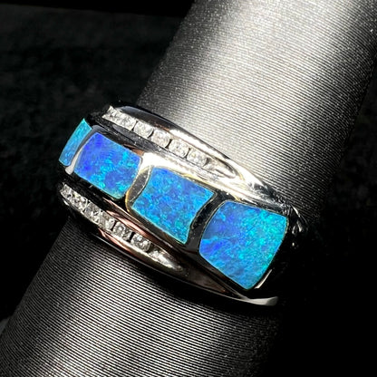 Angled close-up of women's Australian opal inlay and diamond ring in 14k white gold, shown on ring display