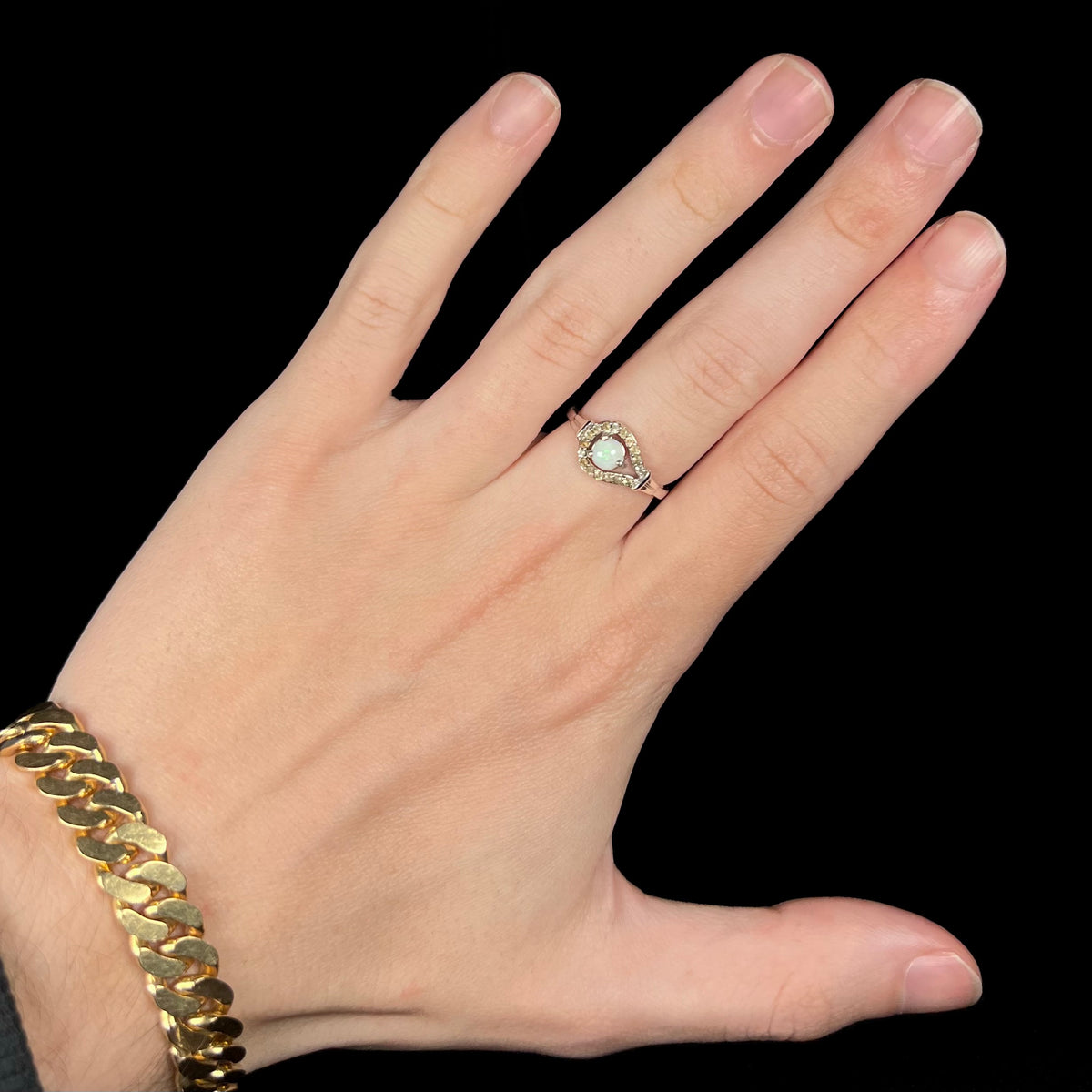 Hand wearing women's sterling silver round Australian white opal ring with smoky quartz halo design