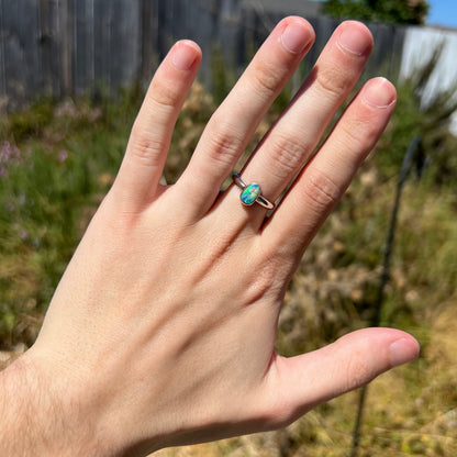 Hand wearing women's fine silver Australian crystal opal ring in natural sunlight