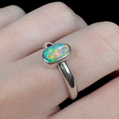 Orange flashes seen in women's silver Australian crystal opal ring, worn on finger