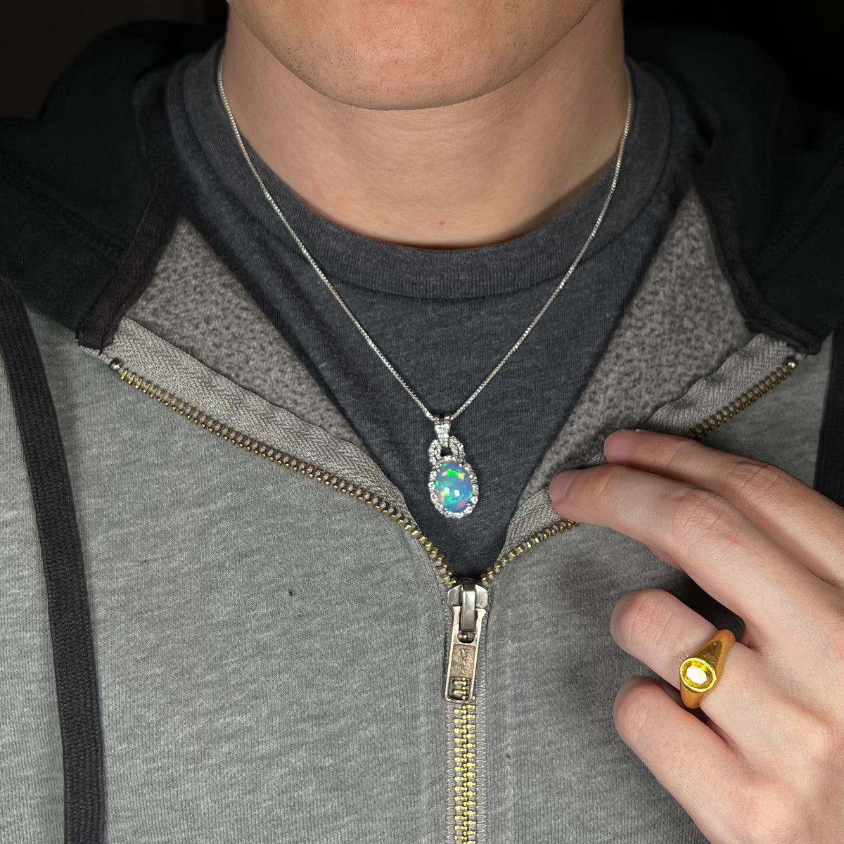 Close-up of person wearing women's sterling silver Ethiopian opal halo design necklace around neck