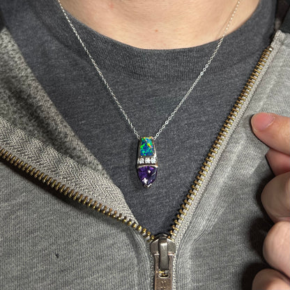 Close-up of person's neck and chest wearing a women's sterling silver lab-created opal inlay and purple CZ necklace against a dark shirt.