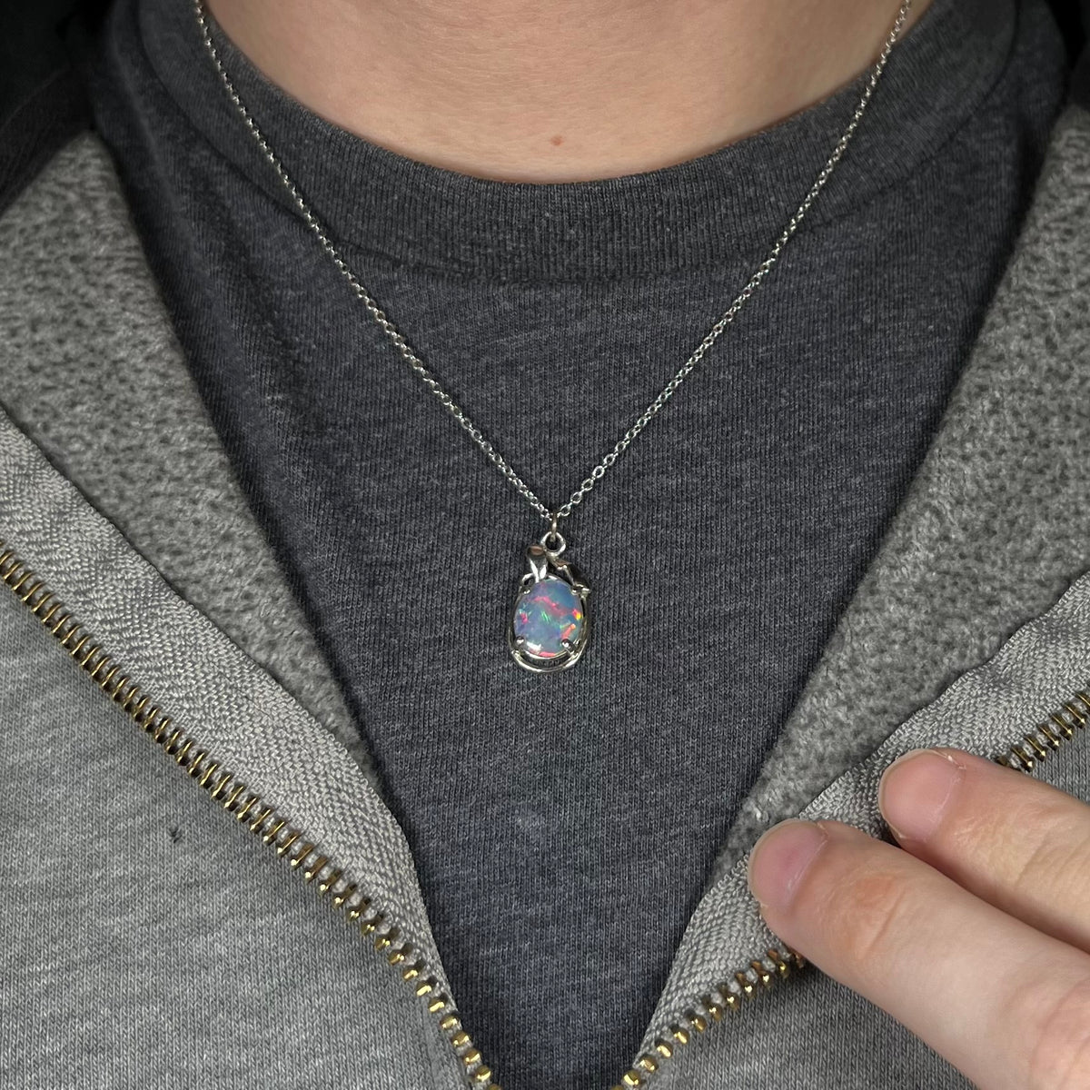 Close-up of person's neck and chest wearing a women's triplet opal necklace made from base metal