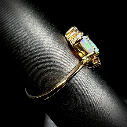 A ladies' gold ring mounted with two marquise cut opals and two diamond accents.